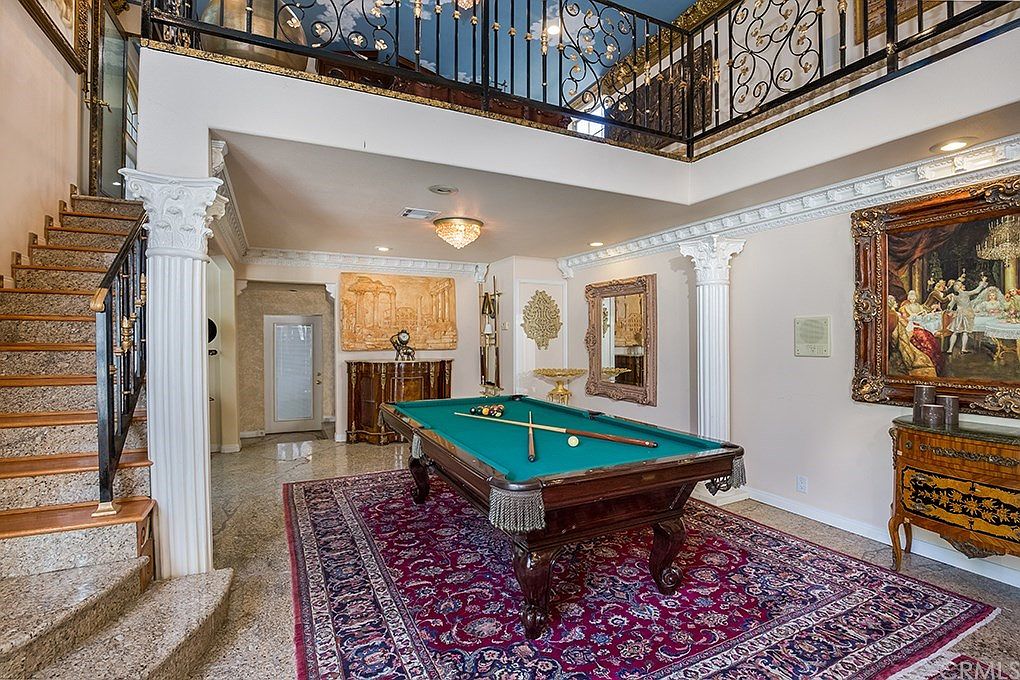 Two-story marble-columned foyer with billiard room and ironwork balustrade at 2215 N Euclid Avenue